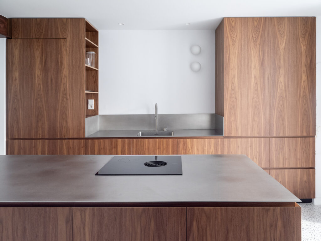 Cocina de Casa Vega con acabado en madera de nogal y encimera de acero inoxidable
