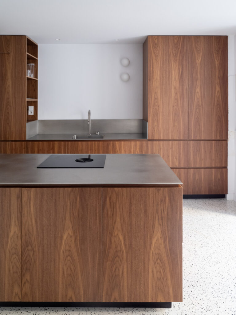 Cocina de Casa Vega con acabado en madera de nogal y encimera de acero inoxidable