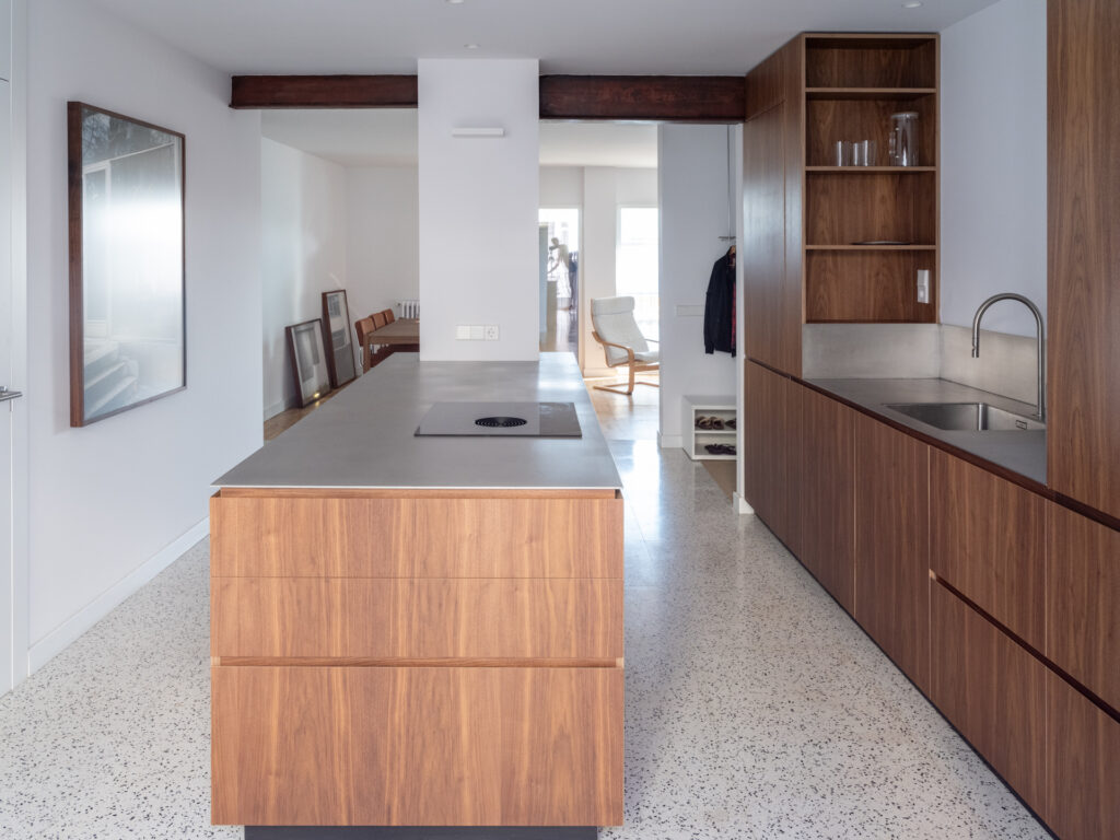 Cocina de Casa Vega con acabado en madera de nogal y encimera de acero inoxidable