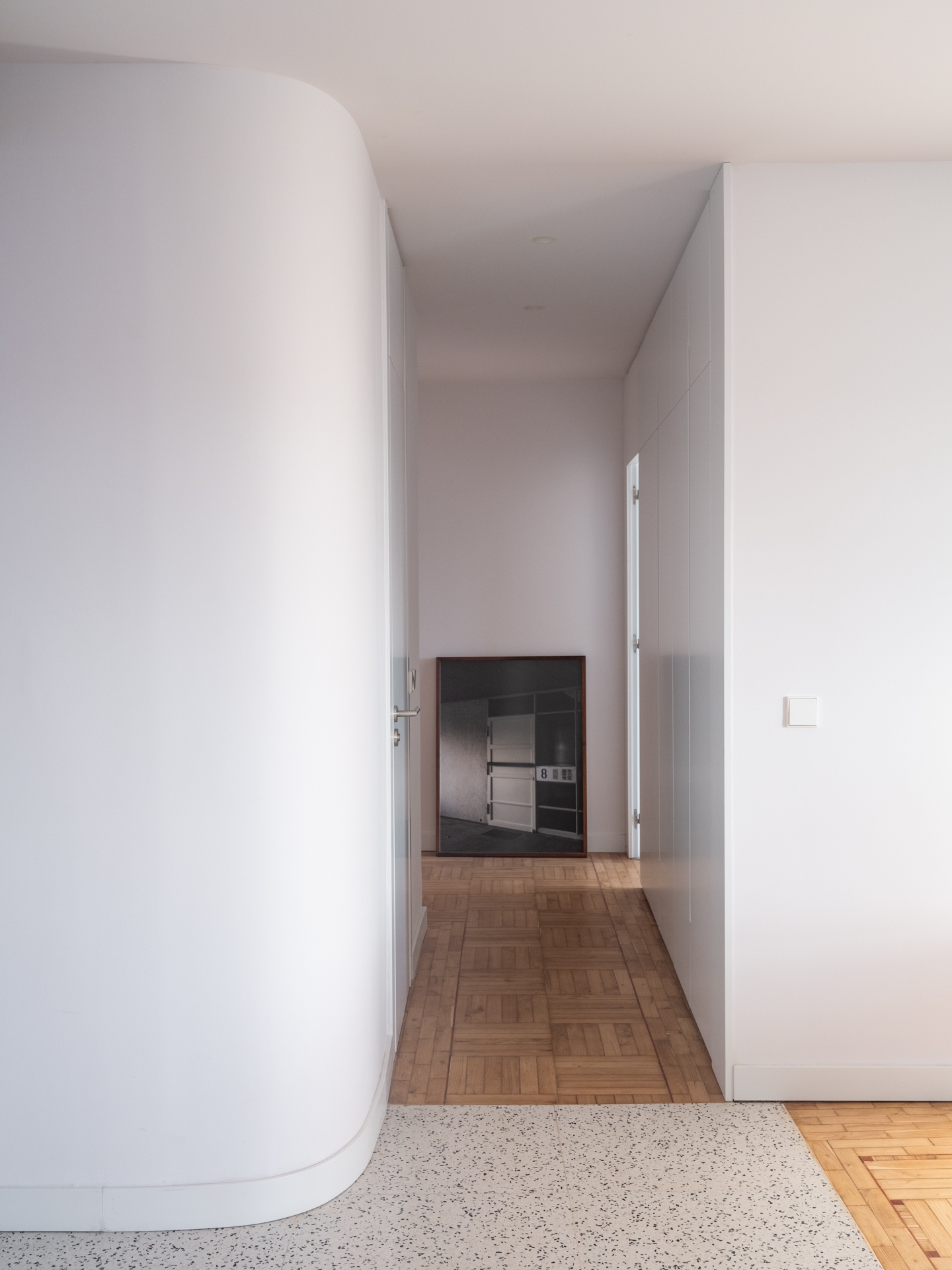 Pasillo de distribución en Casa Vega con panelado continuo en armario y puertas hasta el techo